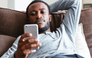 Man sitting on the couch looking at his phone.