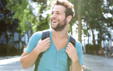 Man with backpack walking and listening to music.