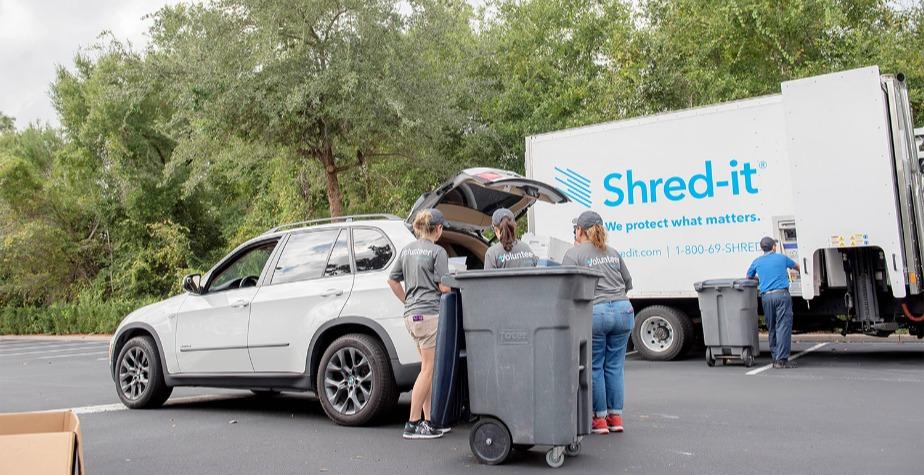 Addition Financial team members unload shred items from a members car.
