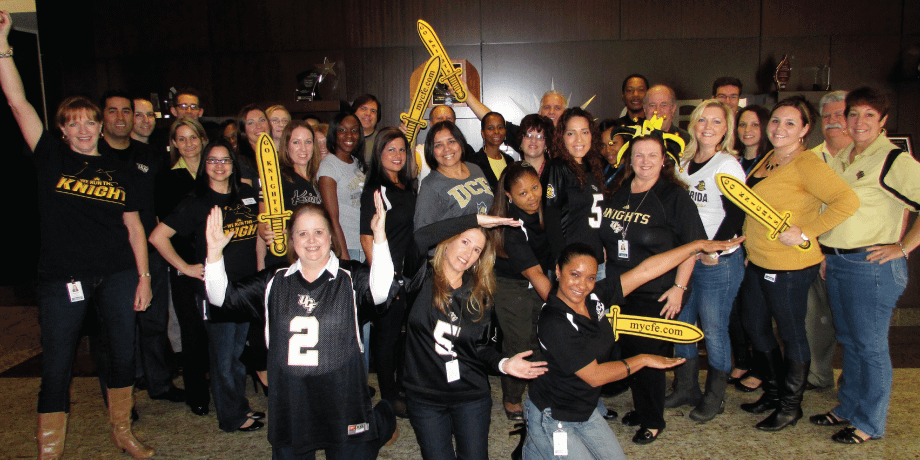 Addition Financial employees wearing UCF jerseys and celebrating 