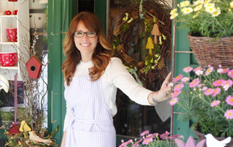 Woman standing outside flower shop.