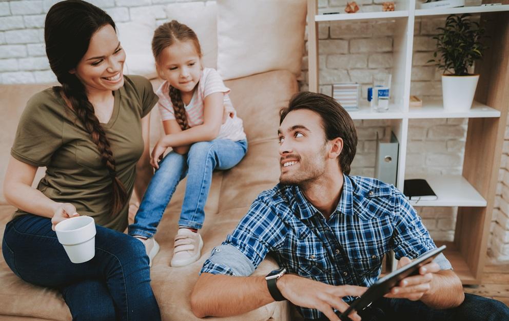 Family talking and drinking tea on a couch