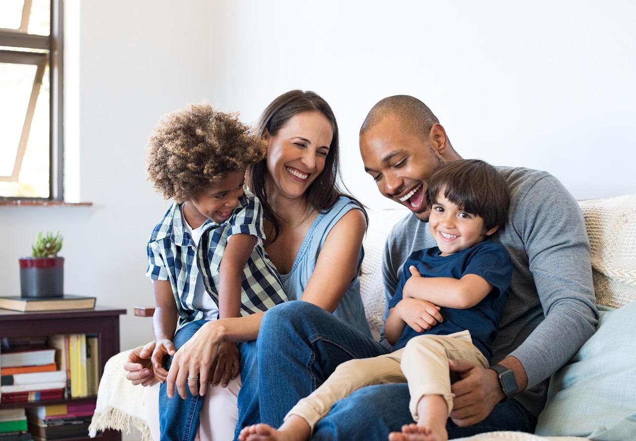 Family laughing with each other on the couch