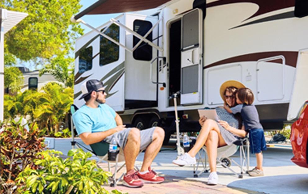 Family relaxing next to an RV