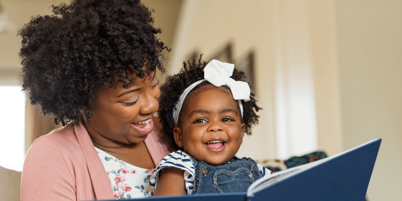 Woman and toddler enjoying reading a book.